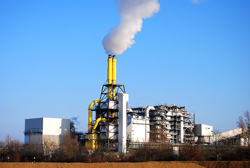 Waste incineration plant with smoke stack against a blue sky