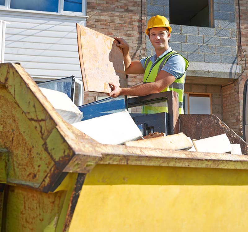 Person loading waste into a skip