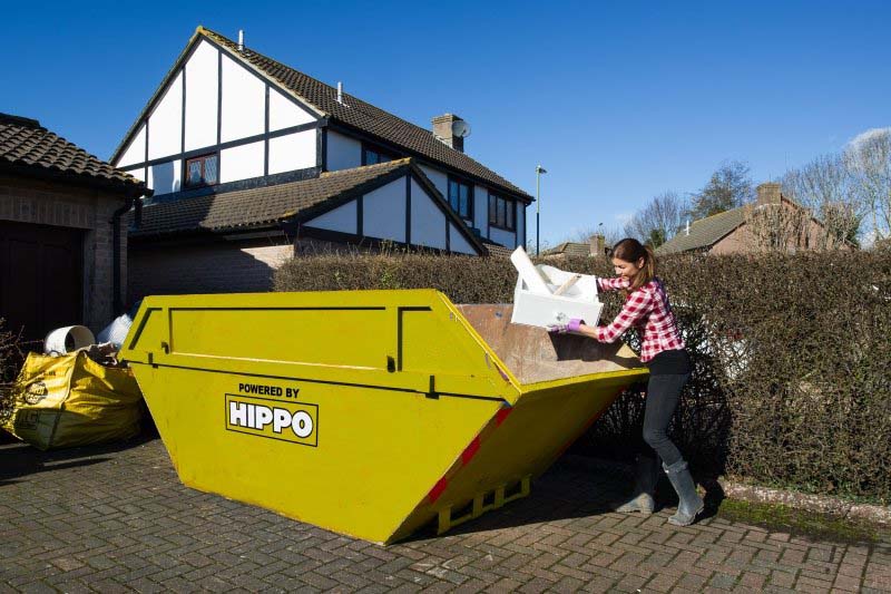 woman-loading-skip-placed-on-driveway.jpg