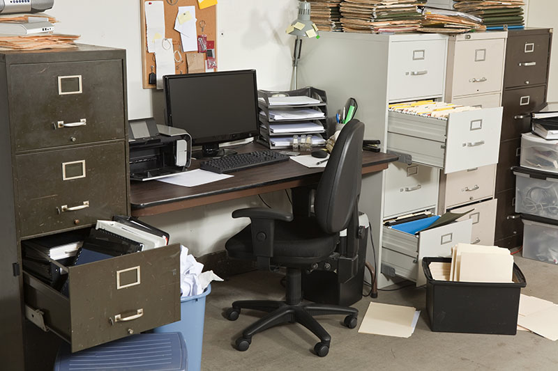 A disorganised office with lots of clutter and mess