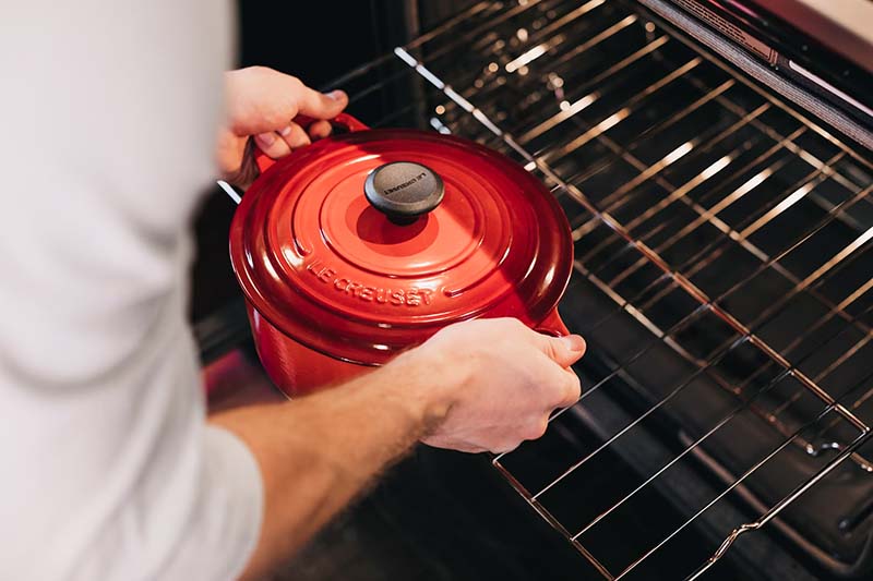 Placing a cooking pot in a hot oven