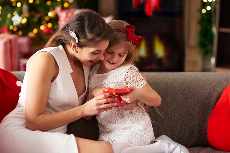 A gift being given to a small child in a red box