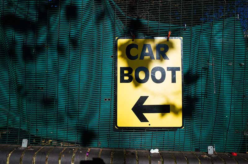 A car boot sign showing the way to the entrance