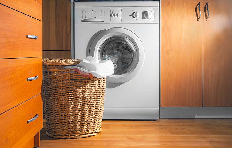 Washing machine with a laundry basket placed in front of it