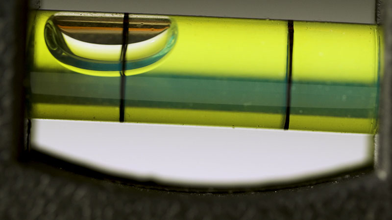 A spirit level bubble showing that there is a tilt as the bubble is to the left side of the level lines