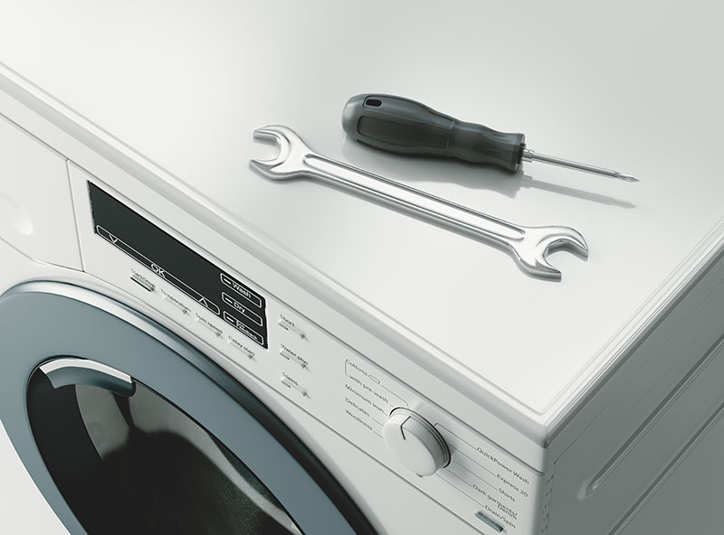 Washing machine with a screwdriver and spanner placed on top of it