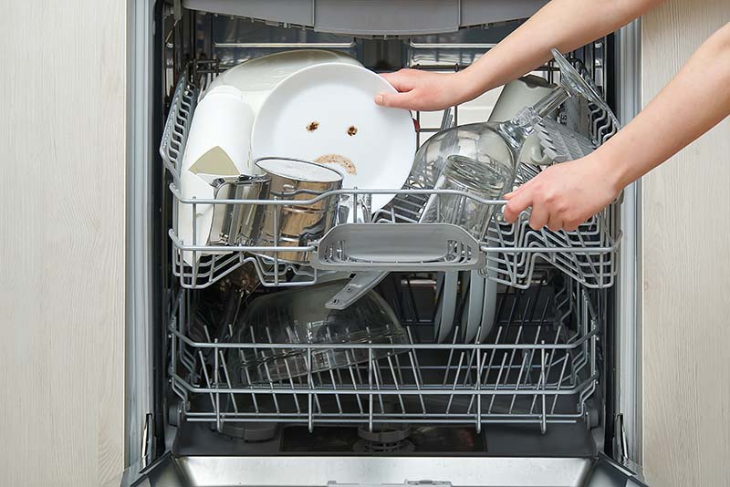 Dirty dishes and utensils in a dishwasher