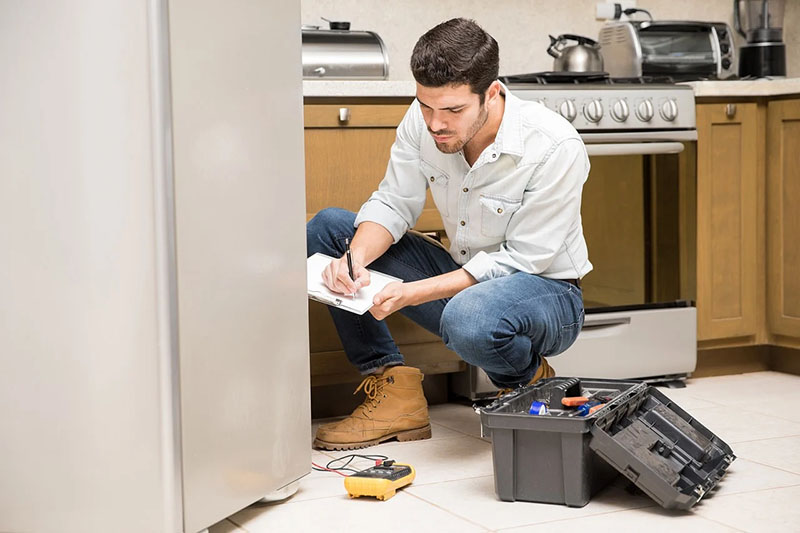 Fridge repairman testing a fridge